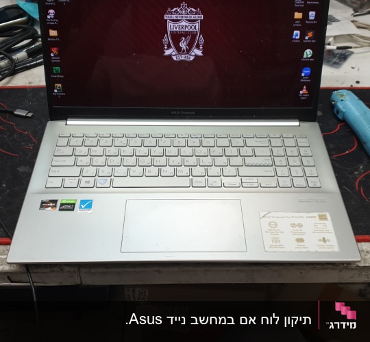 מחשב נייד על שולחן עבודה עם כלים מסביב